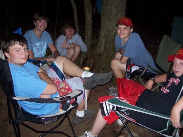 Five scouts sitting in camping chairs looking at the camera.