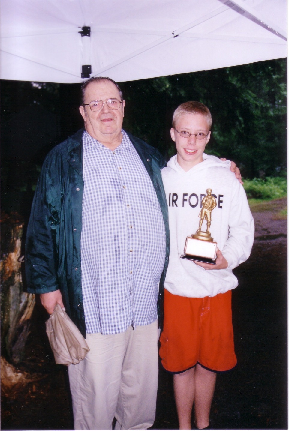 Two people standing on the camera.  The scout on the right is holding the Michael Dikant Award.