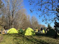 A handful of scouts start among a few green dome-shaped tents.