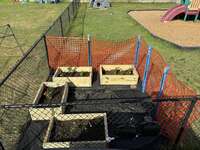 The completed garden boxes with soil and small flowers in them.