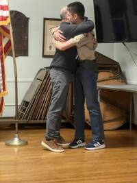 Two people hugging.  One is in a class A.