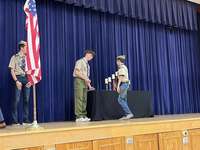 A scout giving an award to another scout.