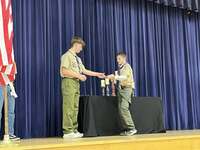 A scout giving an award to another scout.