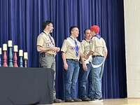 Four scouts and adults talking to each other on stage.