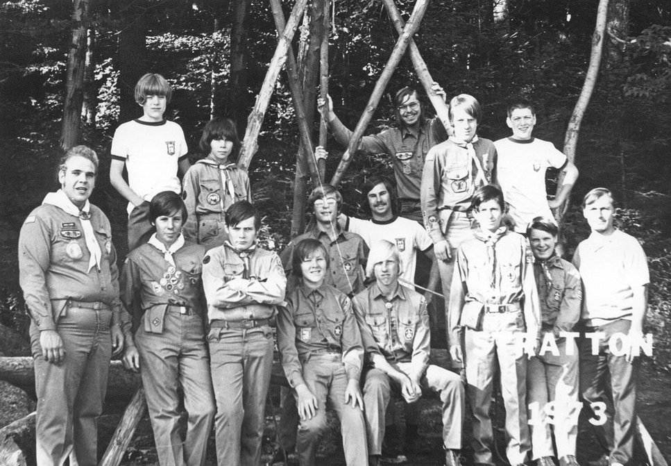 15 people in Class A uniforms smiling for the camera.  There is text in the lower right corner that says 