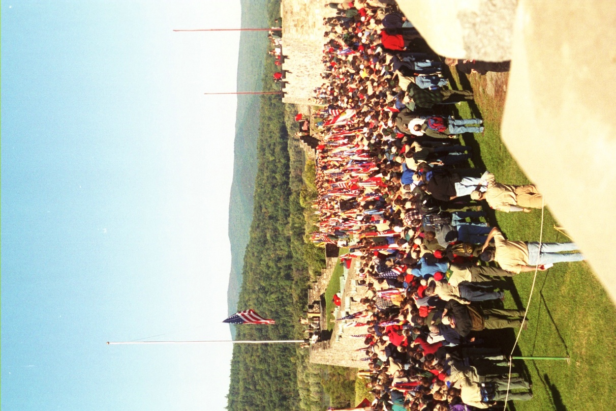 All of the scouts and adults from the campout standing around the flag pole on the fort.  The American flag is half way up the pole.