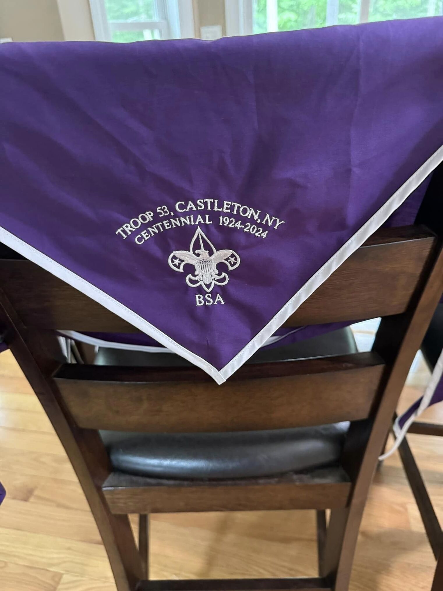 A purple neckerchief with a white border.  The text says 