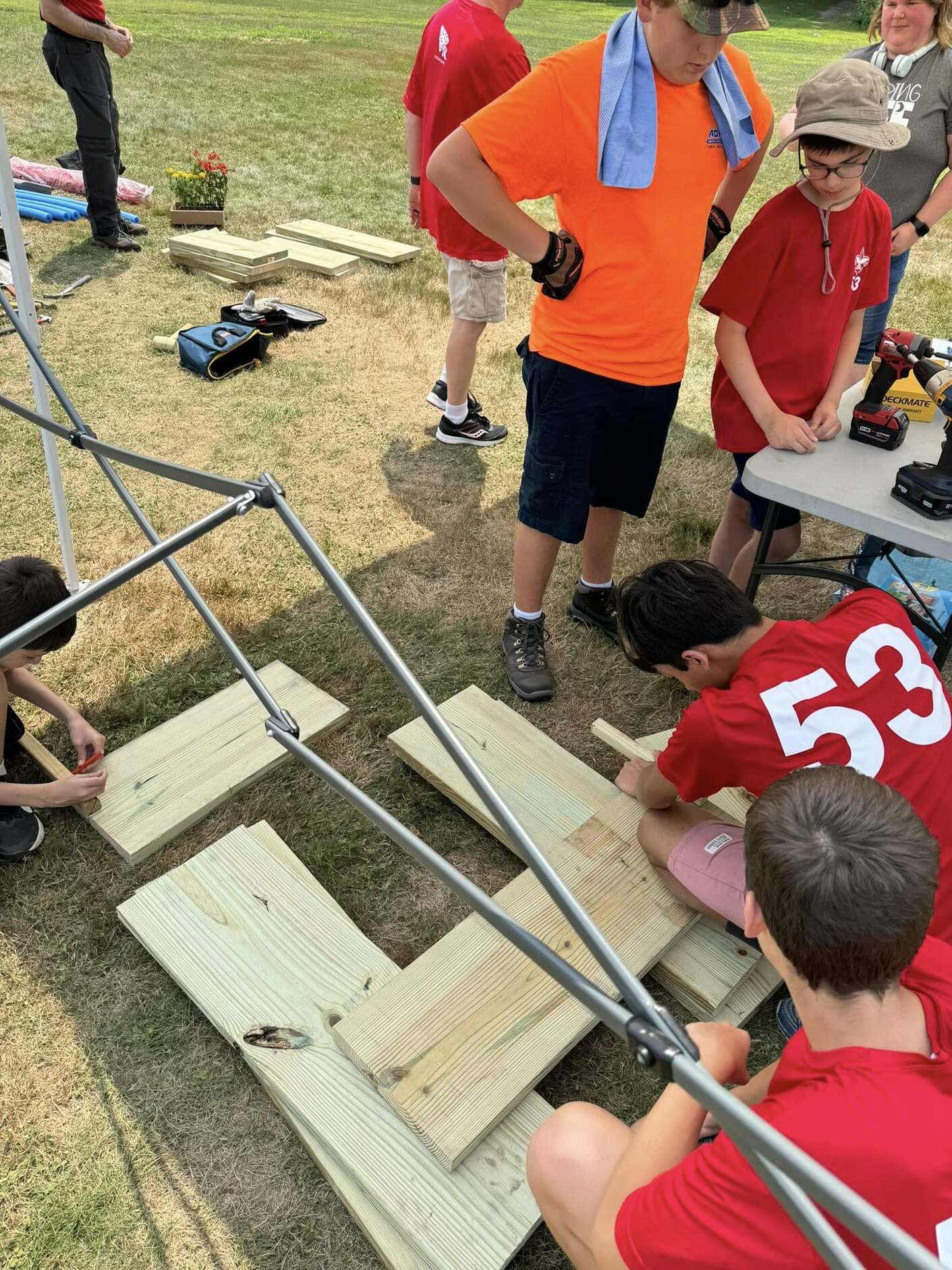 Scouts are drawing on wooden boards.