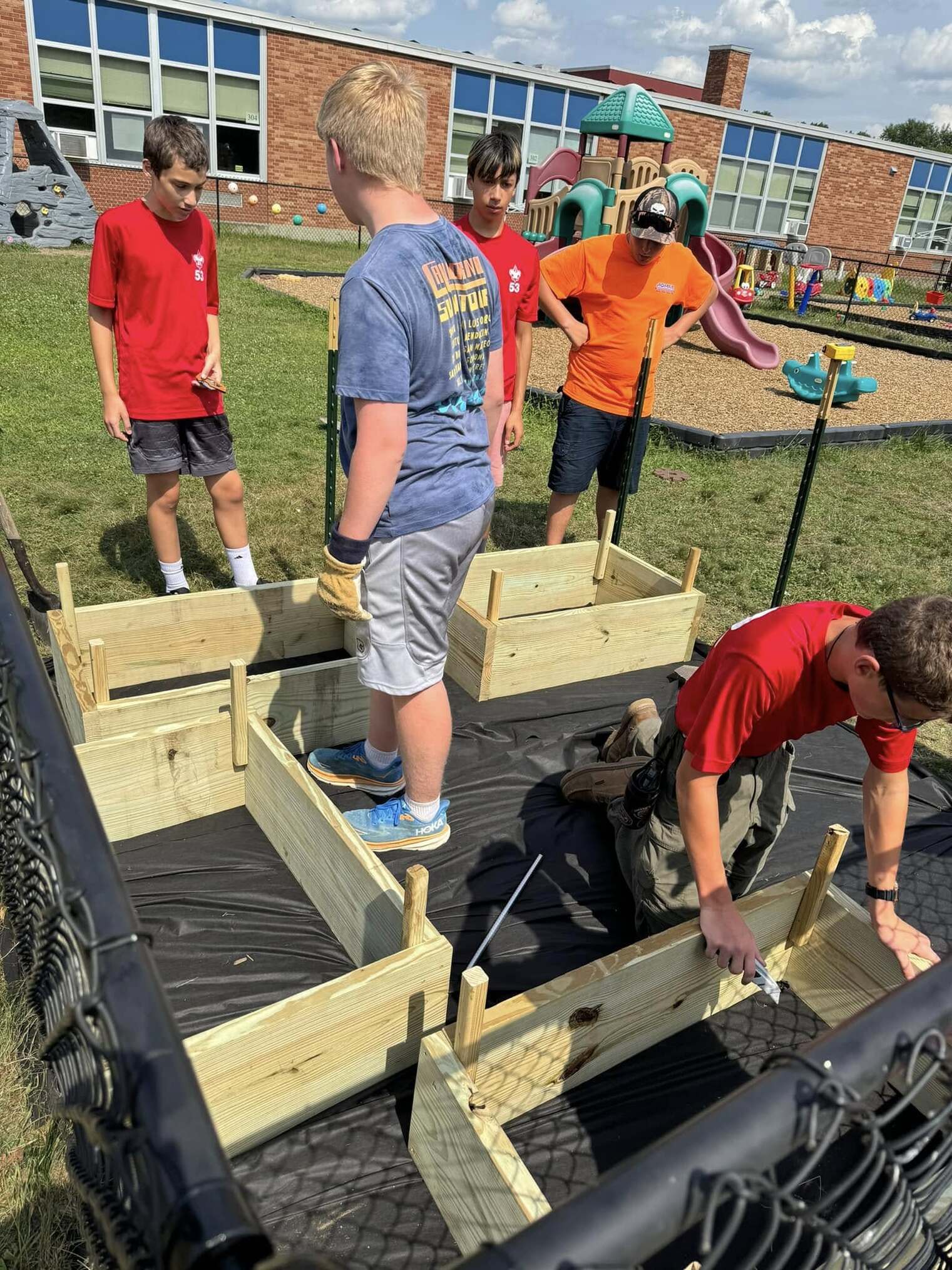 Scouts moving the flower boxes onto a black tarp.