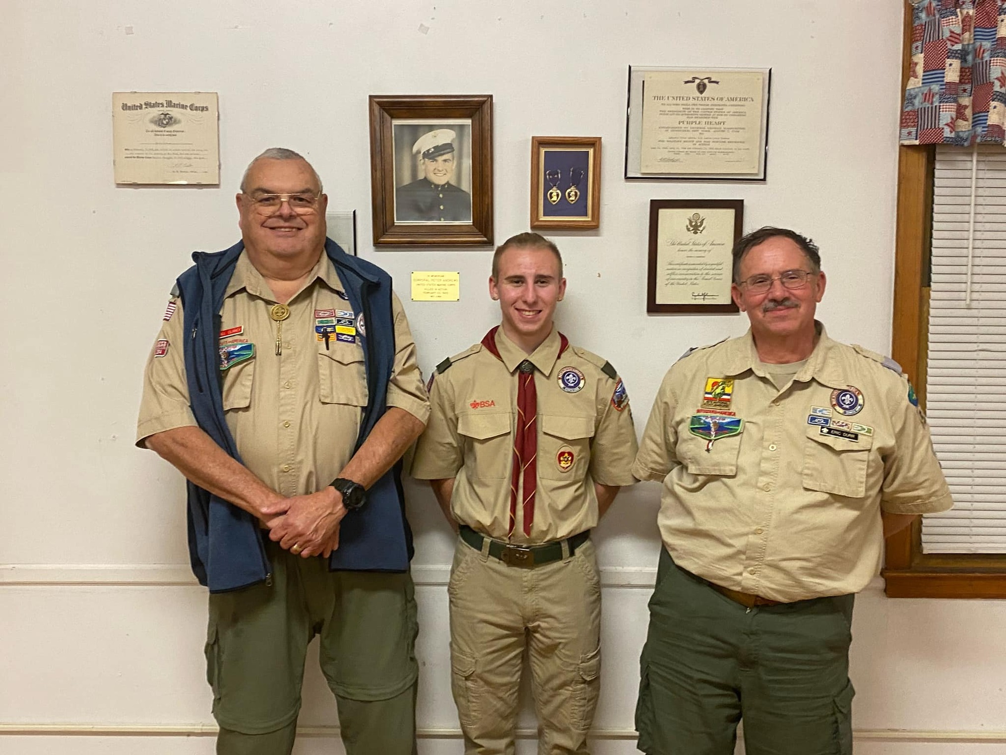 Three people in Class A uniforms smiling at the camera.  Ciaran is in the middle.