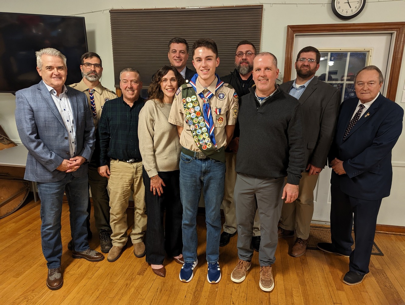 Eleven people smiling for the camera.  Two of whom are in class A uniforms.