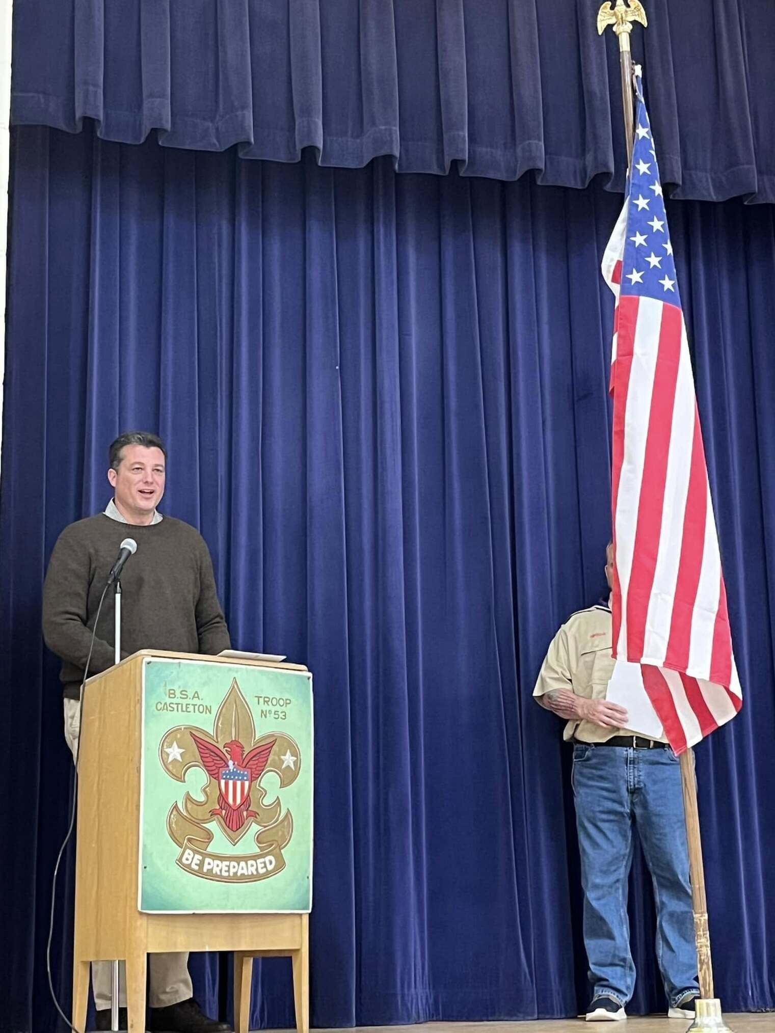 A man speaking into a microphone at a podium.