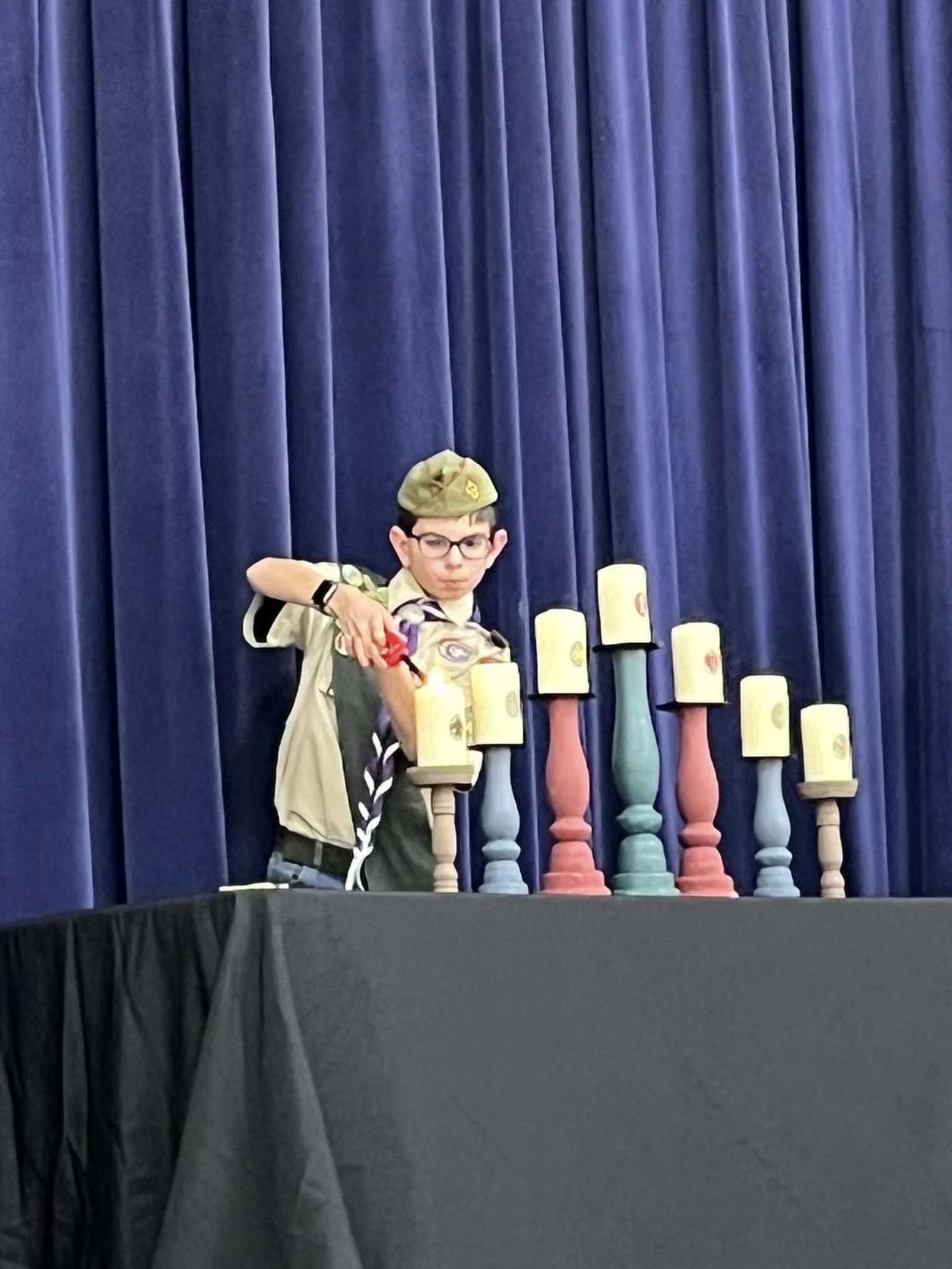 One scout lights a candle on the stage.  There is one candle per scout rank.