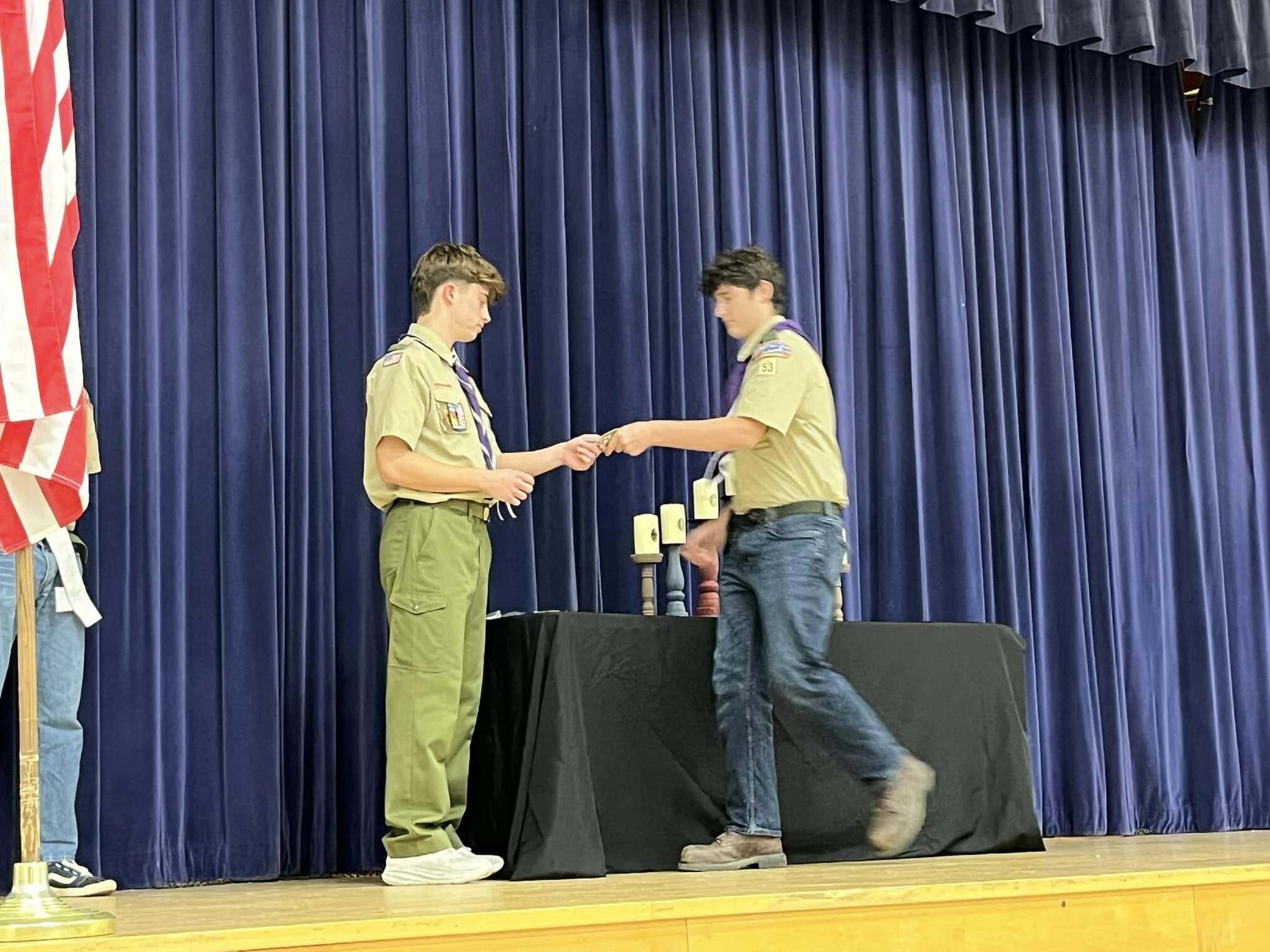 A scout giving an award to another scout.