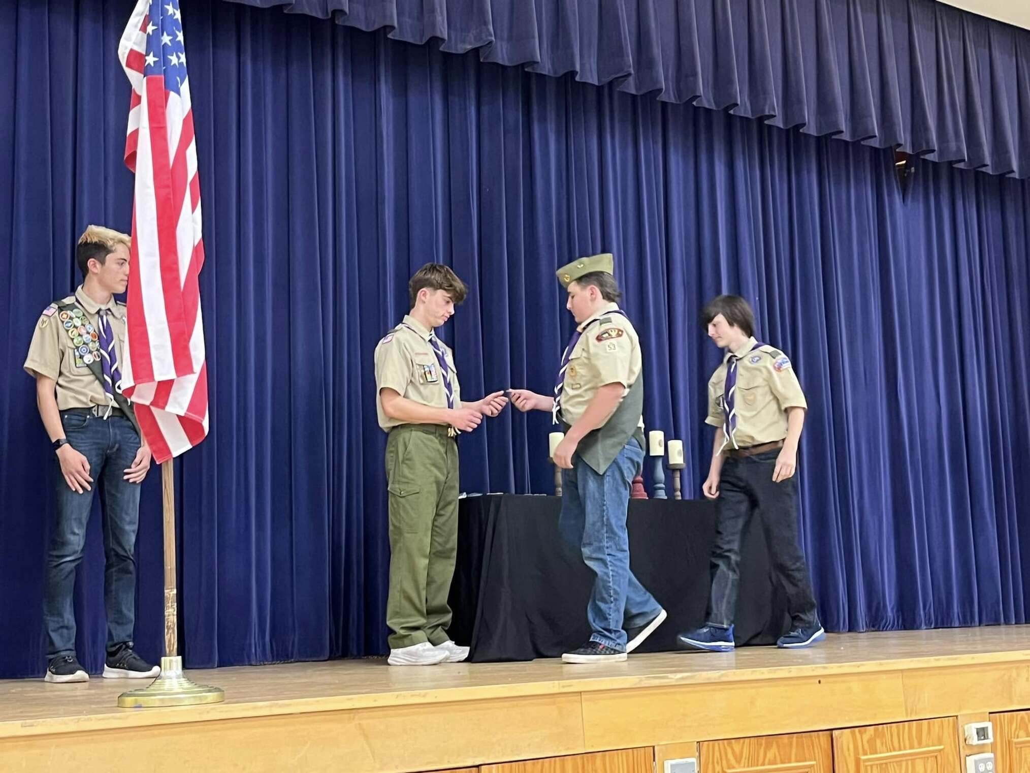 A scout giving an award to another scout.