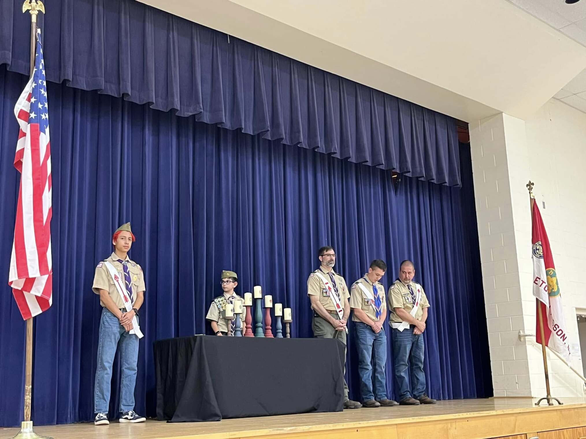 Five scouts and adults standing on stage.